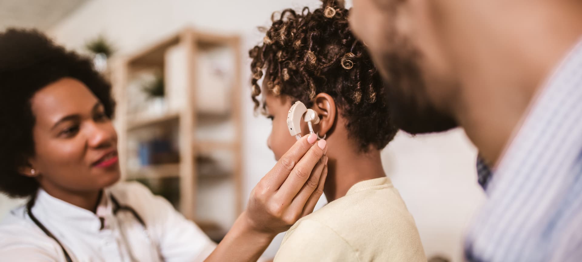 A doctor putting a cochlear implant in a child's ear