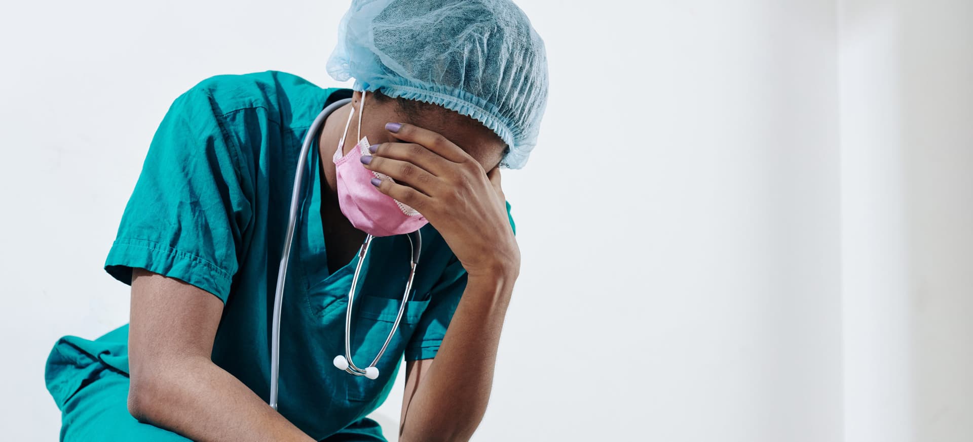 Exhausted healthcare worker with hand over head