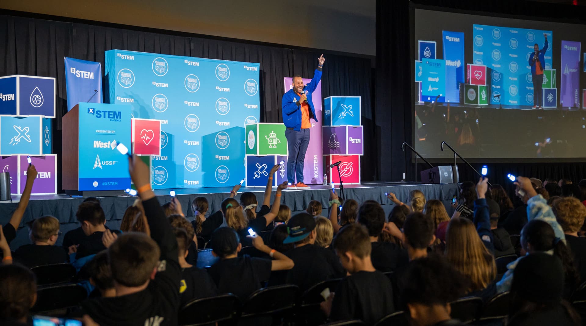 Roy Moye singing in front of an audience of kids during a STEM outreach event