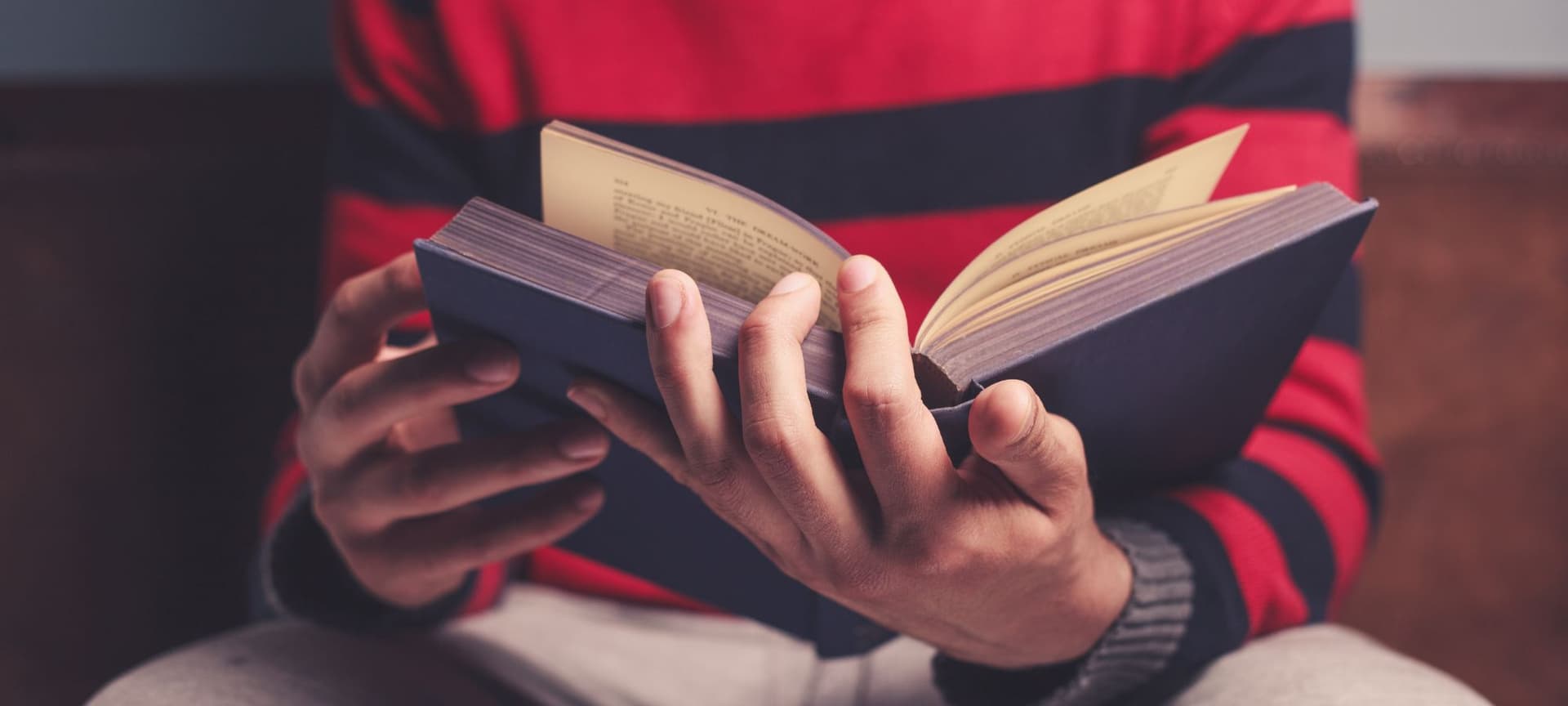 A closeup of a person's hands holding an open book