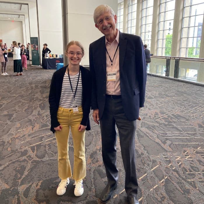 A picture of Kendra Terpstra's daughter Vienna standing with Dr. Francis Collins at the 2024 BioLogos Faith and Science Conference.